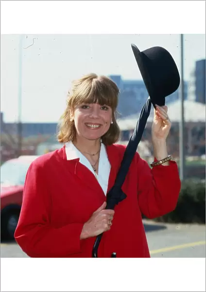 Diana Rigg actress April 1984 wearing red jacket holding bowler hat and umbrella