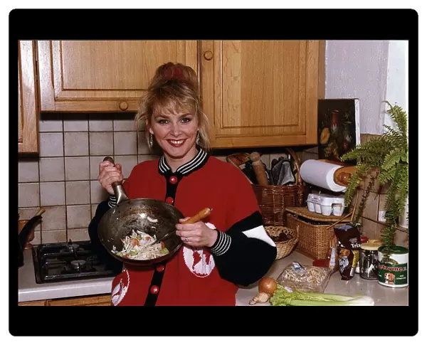 Cheryl Baker former Bucks Fizz singer and TV presenter cooking a stir fry in her kitchen
