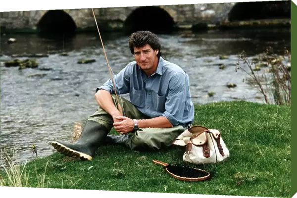 Jeremy Paxman tv presenter of Newsnight and journalist with his fishing gear on riverbank