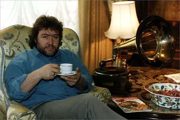 Gregor Fisher Actor Star of Rab C Nesbittsitting in chair drinking a cup of tea