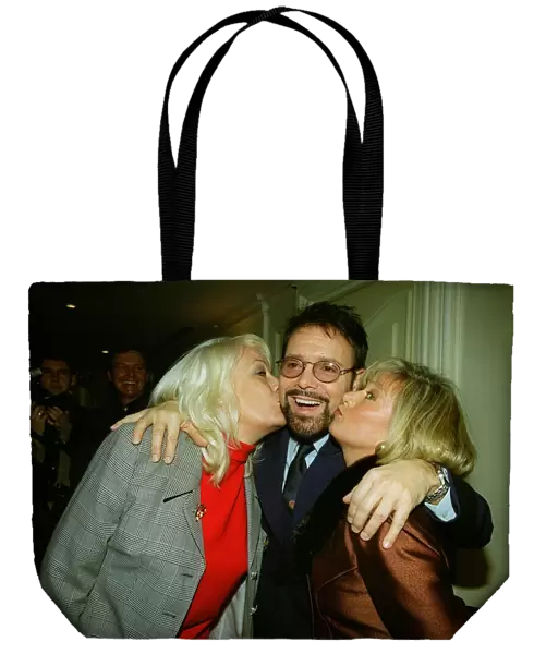Singer Cliff Richard receives a kss on the cheek from Eastenders actress Wendy Richard