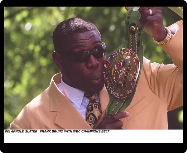 Frank Bruno holds up and kisses his WBC boxing championship belt the day after becoming