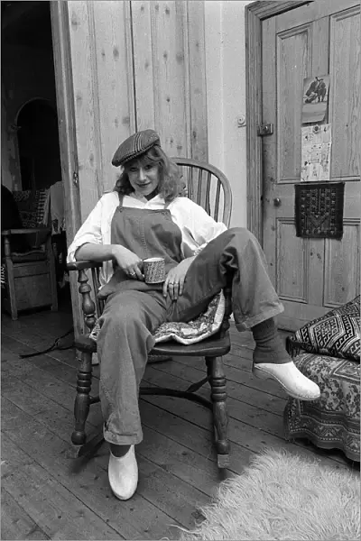 Actress Helen Mirren seated in her country Windsor chair wearing her favorite cap