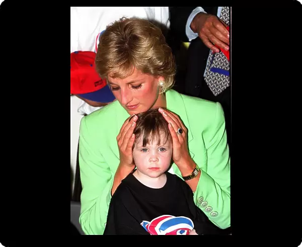 Princess Diana sitting with Caitlin Hines on her lap during a visit to a children