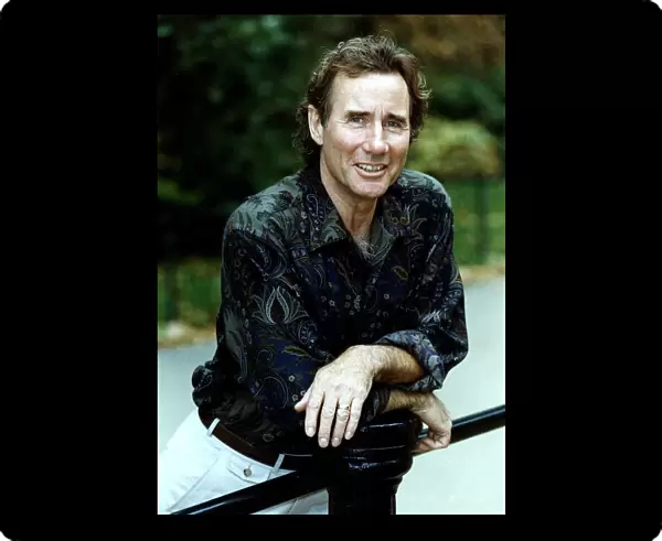 Jim Dale British Comedy Actor wearing patterned shirt leaning on metal railing