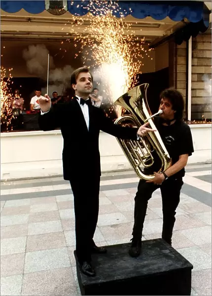 Fireworks director Wilf Scott plays a tuba in front of orchestra conductor Christopher