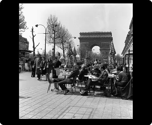 People sitting at a Cafe next to the Arc De Triomphe May 1960