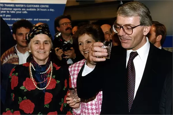 John Major Prime Minister holding a glass of water at the Ideal Home Exhibition in London