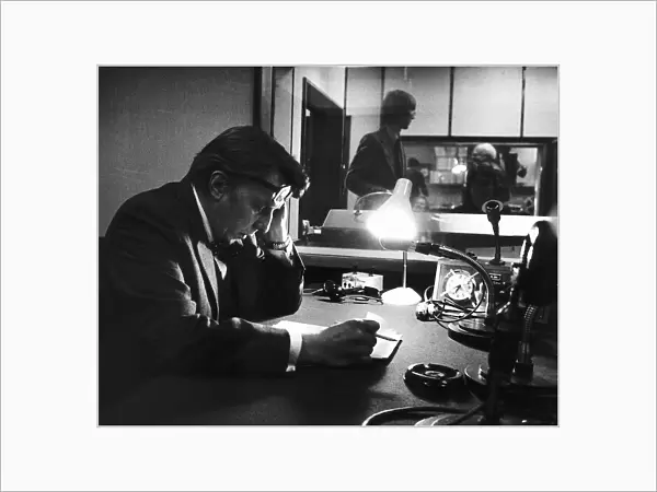 Sir Robin Day TV Presenter and Broadcaster sits in a radio studio studying his script