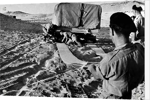 Eight Army soldiers using mats to release a lorry trapped in soft sand in Egypt 1942 WW2