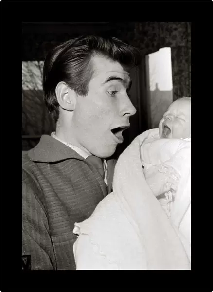 Jim Dale holds his new born baby girl Jane Belinda after her birth at a nursing home in