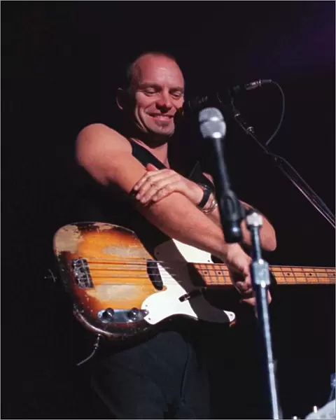 Sting rock singer on stage in Aberdeen commenting on how cold it is rubbing his arm with