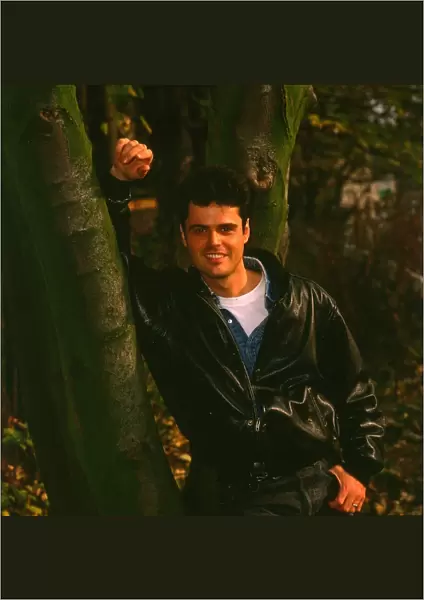 Donny Osmond singer Osmonds pop group November 1988 Leaning on a tree smiling