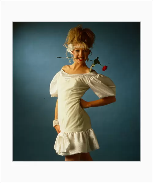 Wedding dress fashion, June 1986 model wearing white mini dress with rose flower in