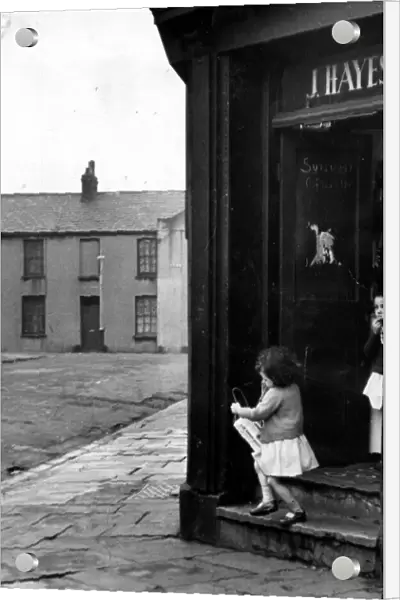 Cardiff - Old - A young child leaves a typical Cardiff corner shop in Butetown