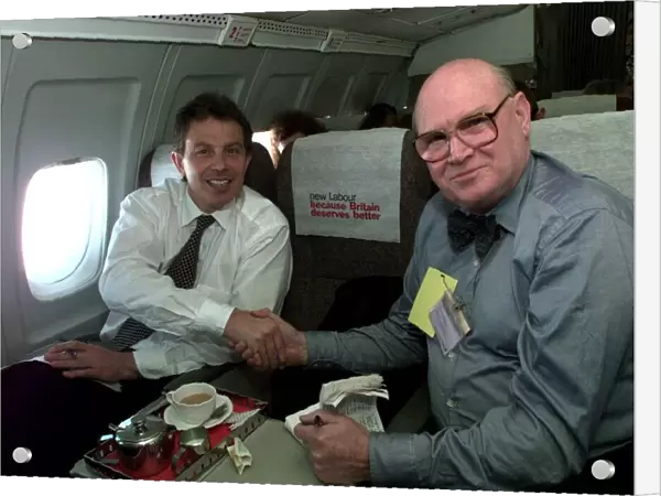 Tony Blair shakes hands with journalist Tom Brown inside aircraft on its way to Edinburgh