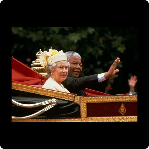 Nelson mandela waves from the carriage as he sits beside Her Majesty Queen Elizabeth II