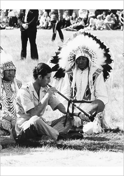 Prince Charles attending a Blackfoot Indian ceremony at Calgary Canada puffs a