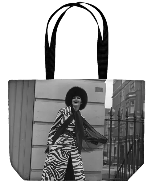 Christine Maxey wearing a zebra print trouser-suit and tunic top with black hat