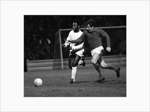 Brazilian football star Pele of Santos chases for the ball with Alan Mullery of Fulham