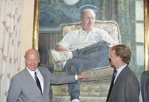 Manchester United director Bobby Charlton standing in front of a painting of him at