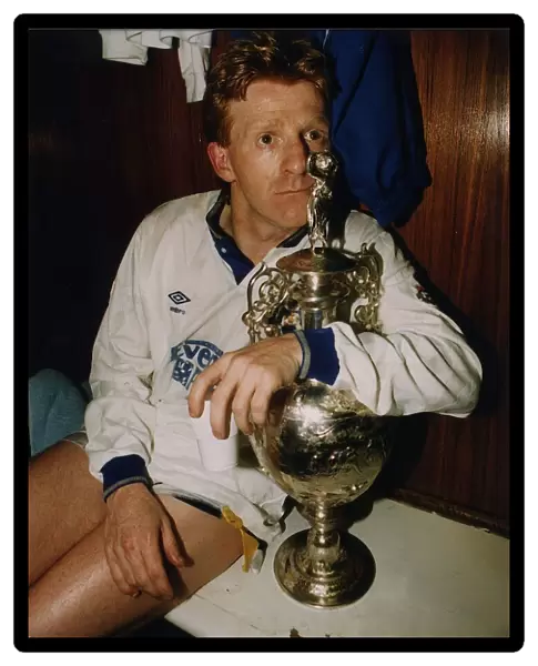 Leeds United footballer Gordon Strachan holds the league division championship trophy