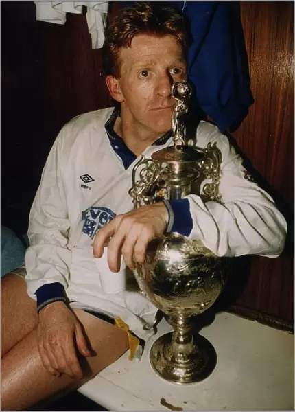 Leeds United footballer Gordon Strachan holds the league division championship trophy