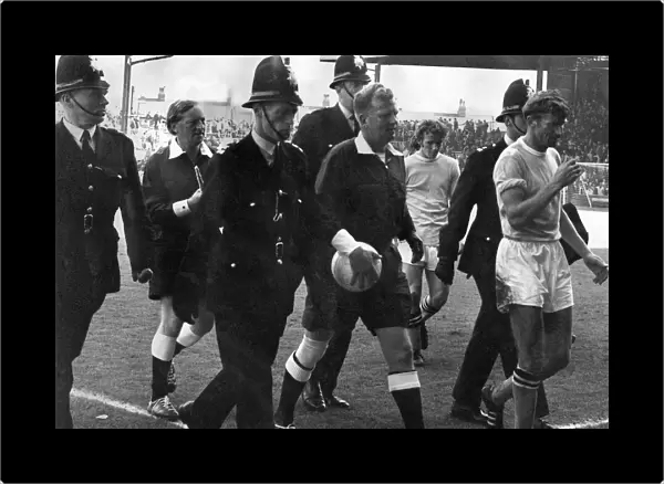 Referee David Smith gets a police escort as he leaves the Maine-road pitch following a
