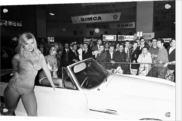 Models drapped over cars at the London Motor Show 18th October 1966