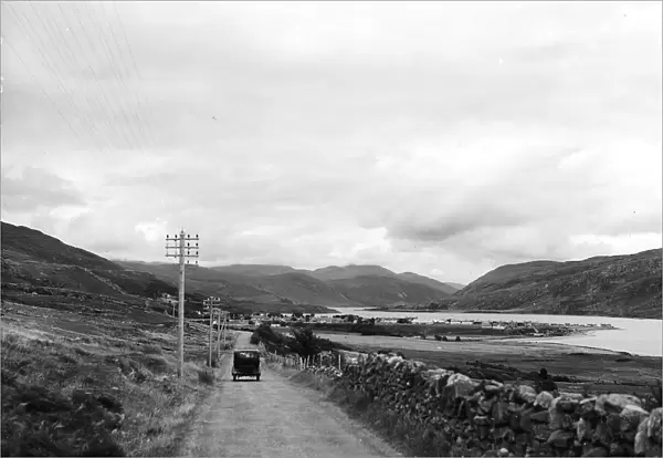 A car driving alond an empty country road by Loch Broom near Ullapool on the west coast