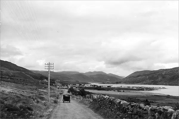 A car driving alond an empty country road by Loch Broom near Ullapool on the west coast