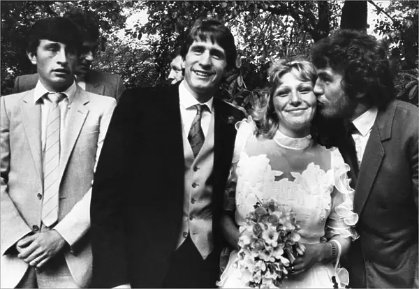 Bride Jackie Manders receiving a kiss from Aston Villa player Peter Withe watched by