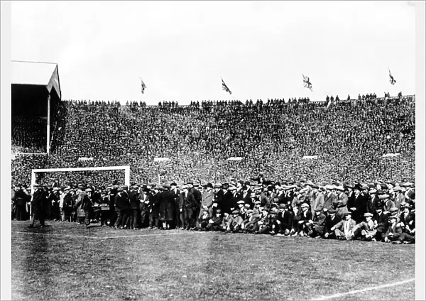 Crowds sit in the goalmouth after they came on to the pitch before the start of the game