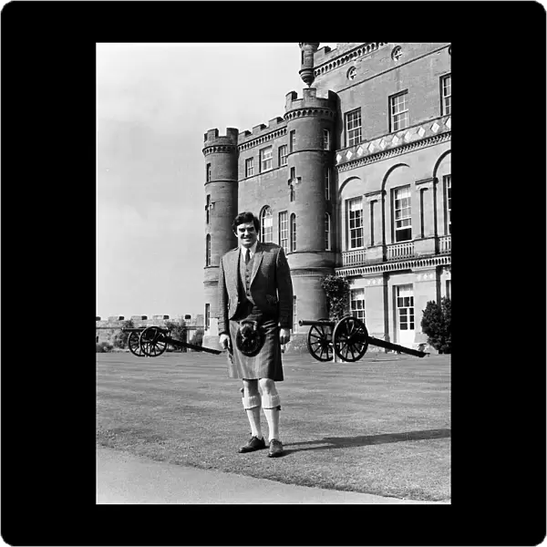 Scottish comedian Jimmy Logan standing outside Culzean castle wearing traditional