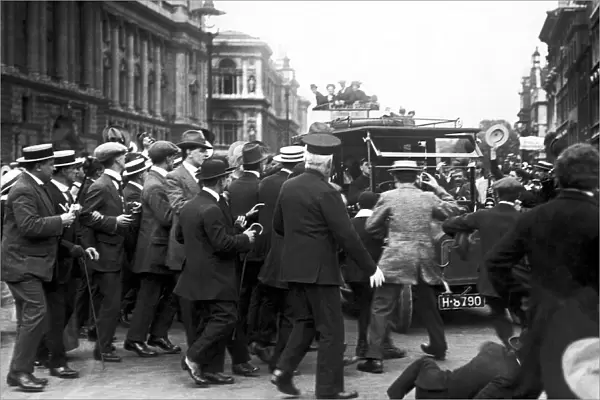 Crowds cheering Prime Minister Herbert Asquith as he returns from parliament following