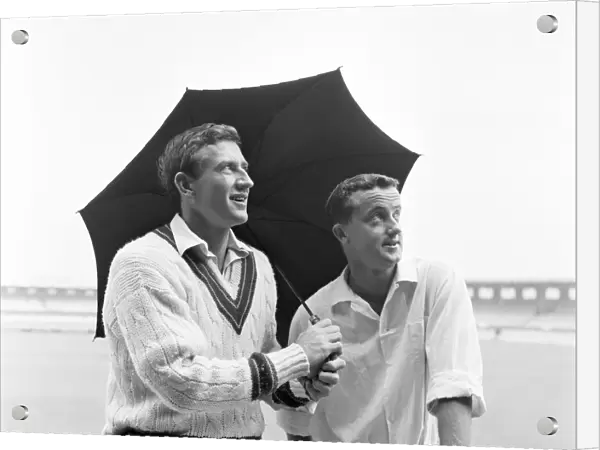 Australian cricketers Graham McKenzie (left) and Grahame Corling take shelter from