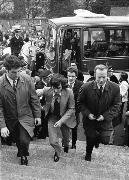 Manchester United football star George Best, surrounded by body guards after receiving