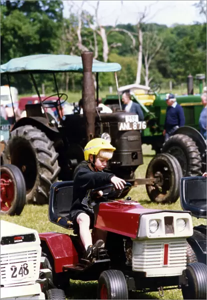 A little boy trying our a miniature tractor on show among the traction engines at