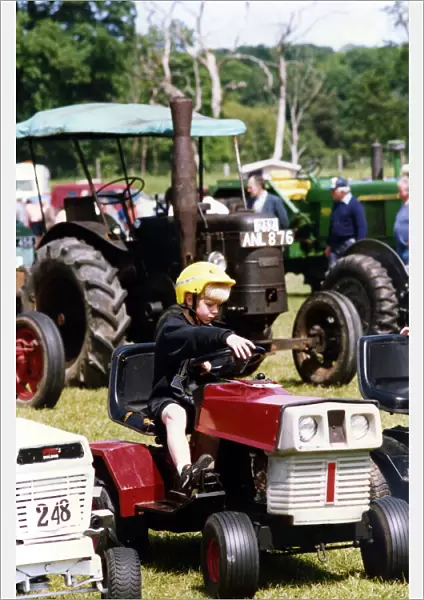 A little boy trying our a miniature tractor on show among the traction engines at