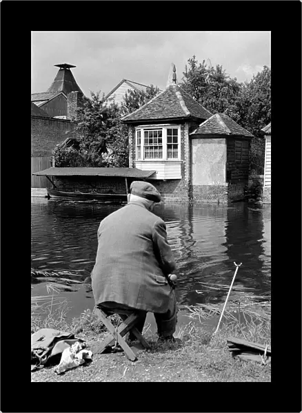 An elderly fisherman on the banks of the river Lea at Ware in Hertfordshire circa 1963
