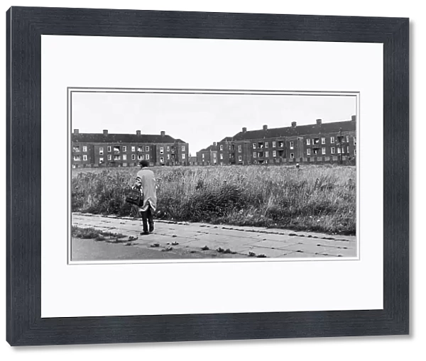 Man walking down a street in the residential suburb f Speke in South Liverpool