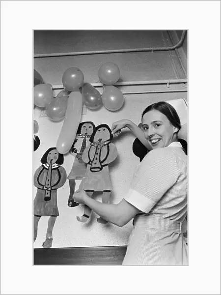 A nurse decorates a childrens hospital in Birmingham. 20th December 1975