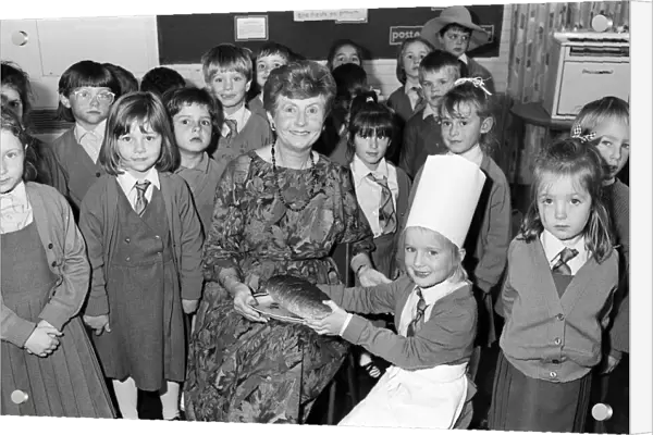Mrs Rita Manchester receives a loaf of bread from six-year old Angela Chapman after a