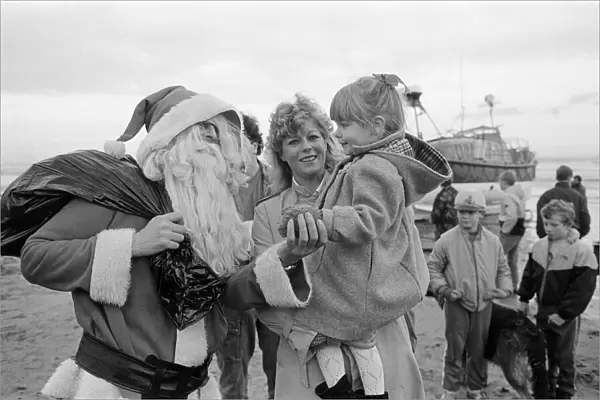 Father Christmas arrives to Newbiggin by lifeboat. Northumberland, December 1985