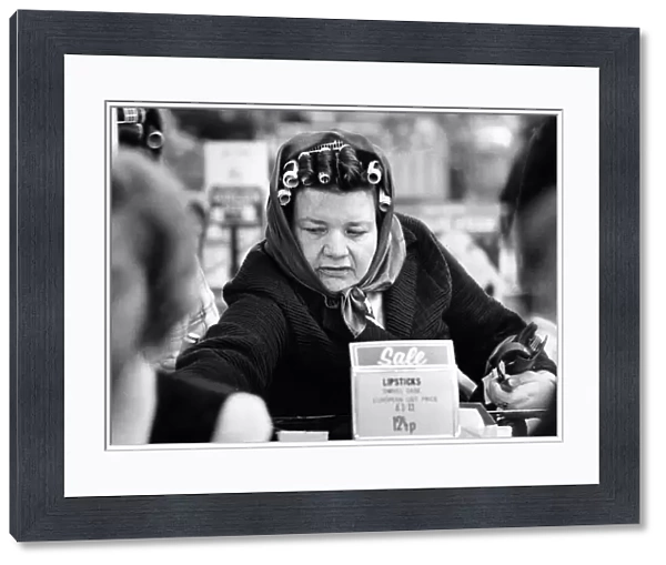A woman wearing curlers in her hair enjoying shopping in the sales after Christmas