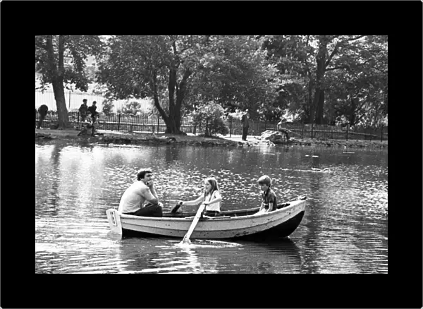 A family enjoying a boat ride on the lake in Albert Park, Middlesbrough, North Yorkshire