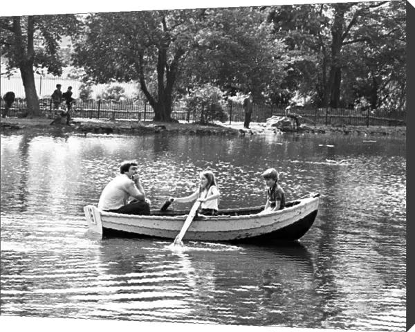 A family enjoying a boat ride on the lake in Albert Park, Middlesbrough, North Yorkshire