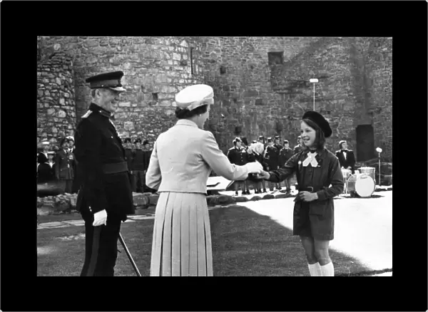 Queen Elizabeth II greets a member of the local brownies, at Harlech Castle, Llandudno