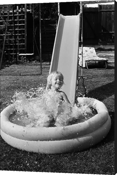 Mark Gordon cools off from the summer sun in his paddling pool. 28th June 1976