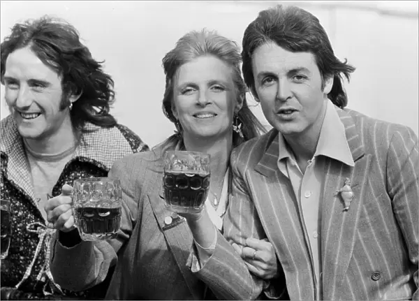 Paul McCartney and his wife Linda of pop group Wings enjoy a pint of ale as they make a